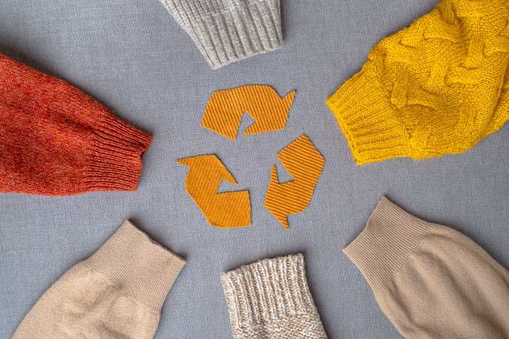 Maniche di vestiti al cui centro compare il simbolo della sostenibilità per combattere il fast fashion