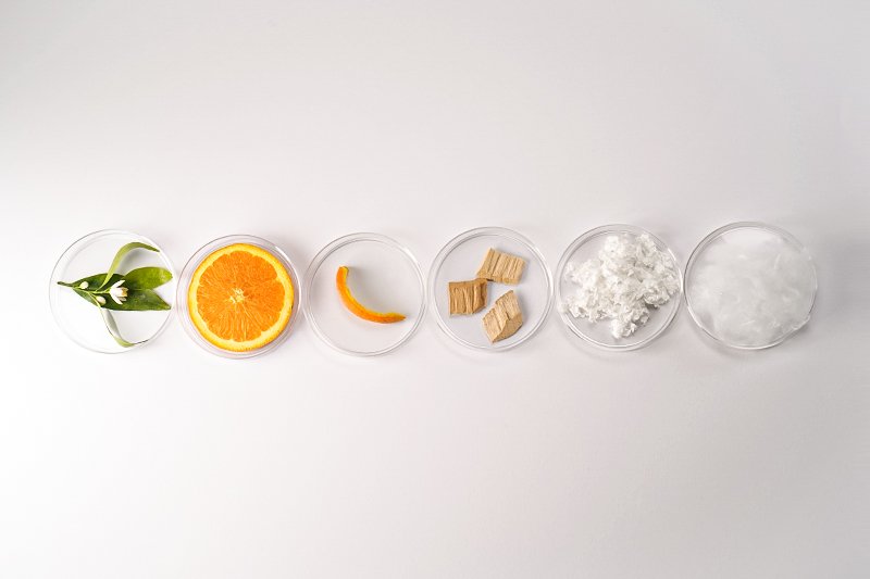 Processo di produzione del Tencel di Orange Fiber, mostrando le diverse fasi: dalla raccolta degli scarti degli agrumi, all'estrazione della cellulosa, alla trasformazione in fibra tessile, fino alla creazione del tessuto sostenibile e innovativo